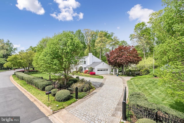 view of front facade with decorative driveway and fence