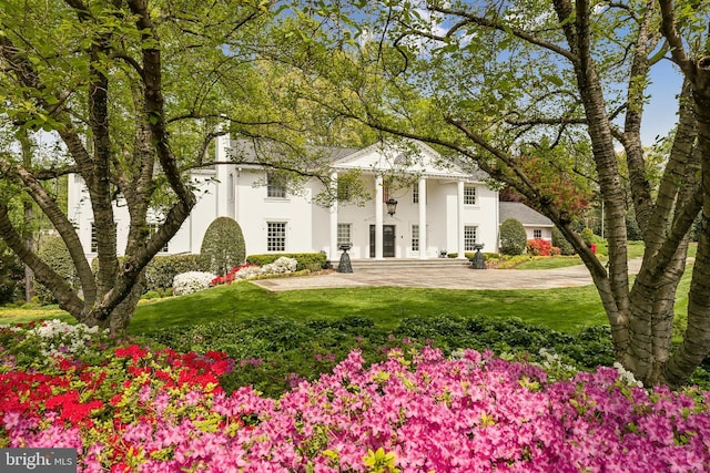 greek revival house with a front lawn and stucco siding