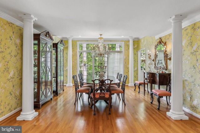 dining room featuring wallpapered walls, ornate columns, and light wood-style flooring