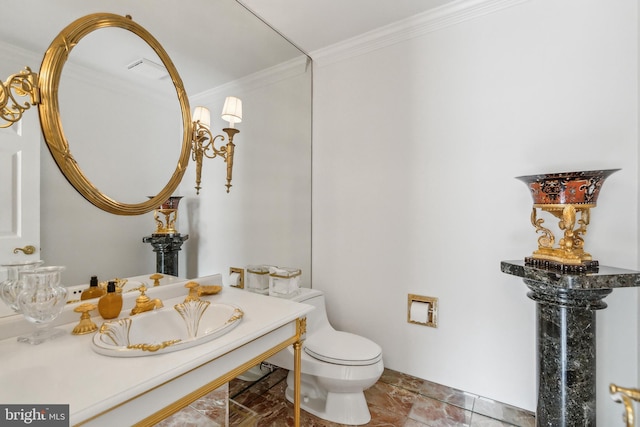 bathroom with baseboards, ornamental molding, toilet, and a sink
