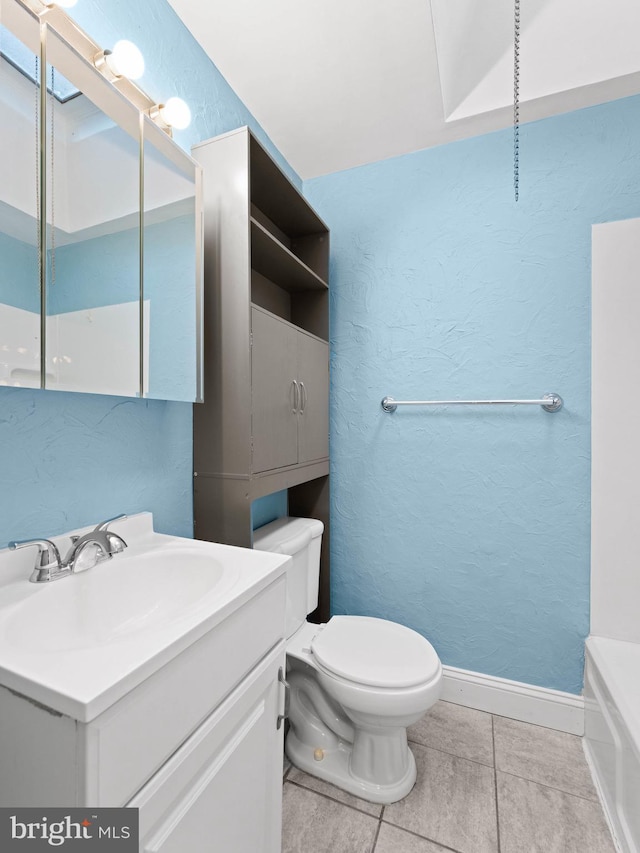 full bath with tile patterned floors, toilet, baseboards, a textured wall, and vanity