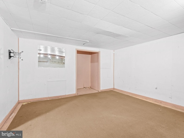 carpeted spare room featuring baseboards