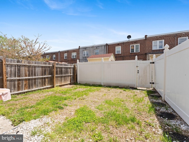view of yard featuring a gate and a fenced backyard