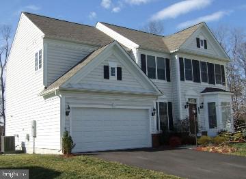 view of front of home featuring aphalt driveway and central AC