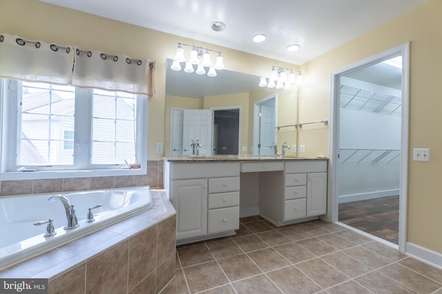 9184 Laurel Highlands Pl, Manassas, VA 20112 - bathroom featuring vanity, a garden tub, tile patterned flooring, a walk in closet, and baseboards