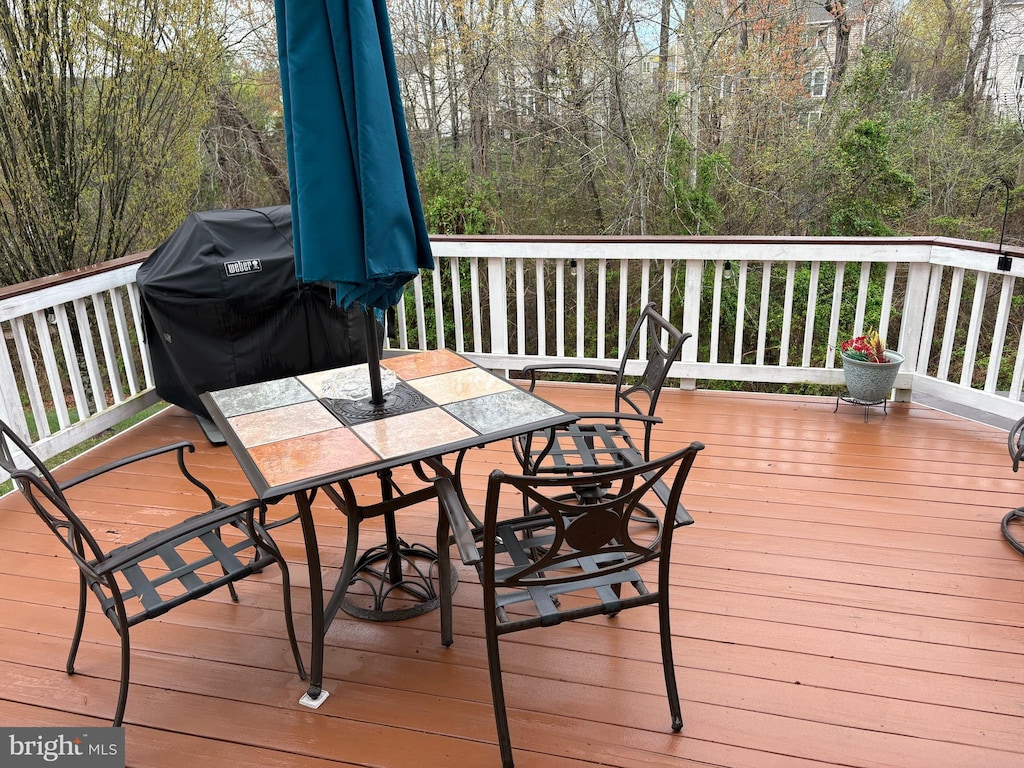 deck with outdoor dining area and a grill
