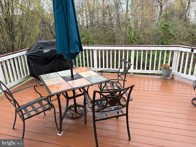 deck with outdoor dining area and a grill