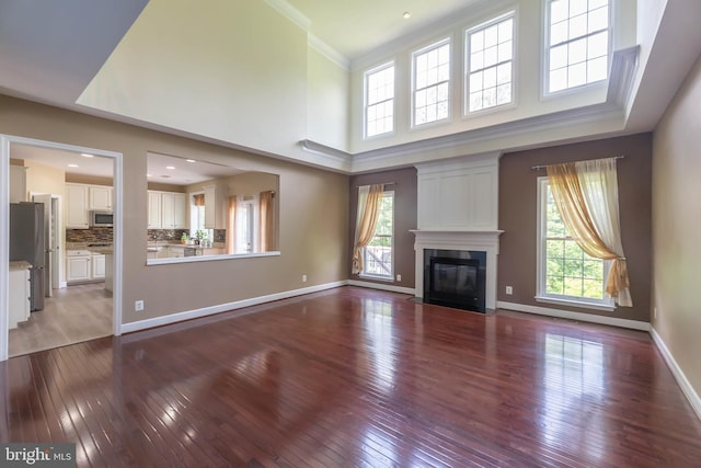 9184 Laurel Highlands Pl, Manassas, VA 20112 - unfurnished living room featuring hardwood / wood-style floors, a fireplace, crown molding, and baseboards