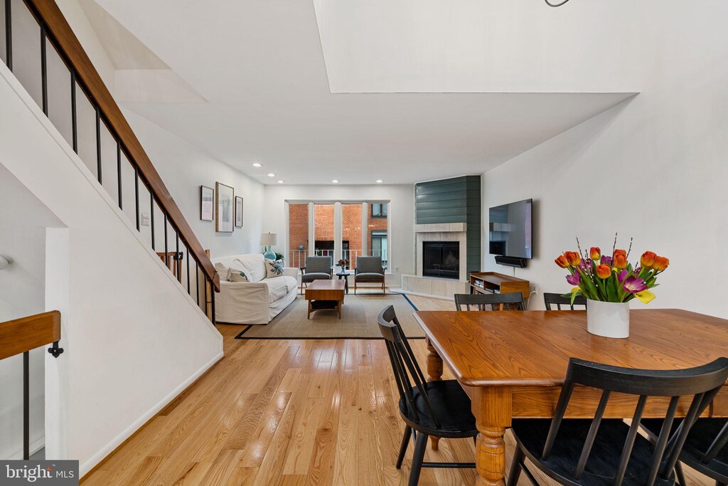 102 Lombard St, Philadelphia, PA 19147 - dining area featuring a fireplace, recessed lighting, light wood-style flooring, and stairway