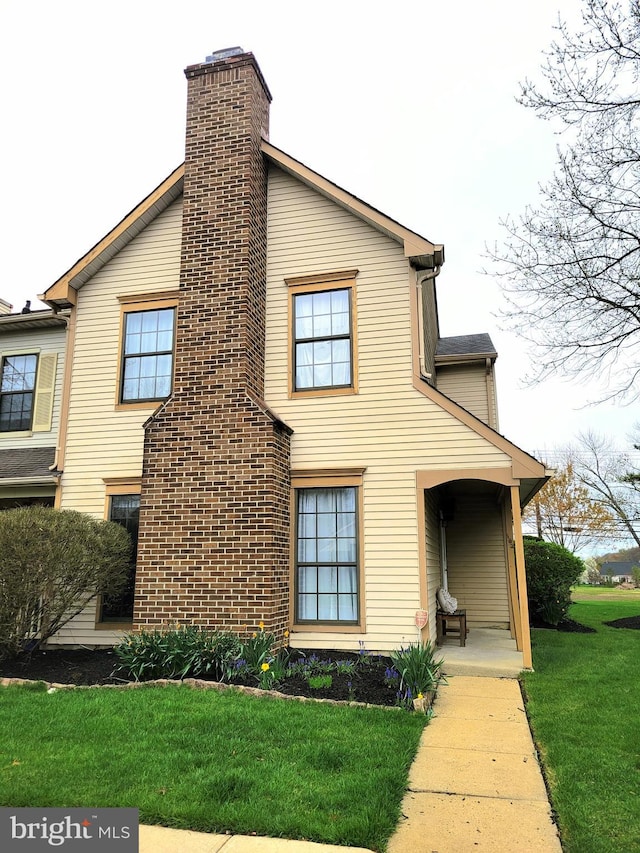 view of front facade featuring a chimney and a front yard