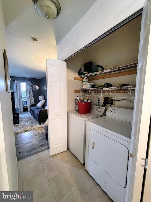 laundry area featuring light tile patterned floors, washing machine and dryer, and laundry area