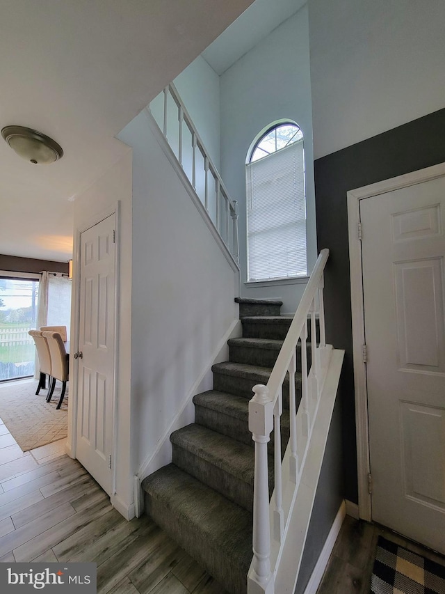 stairs featuring wood finished floors and baseboards