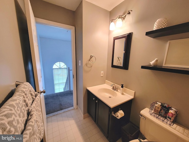 half bath featuring toilet, vanity, and tile patterned flooring