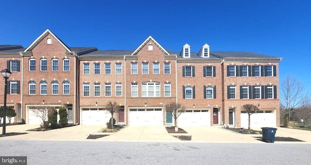 townhome / multi-family property featuring an attached garage, brick siding, and driveway