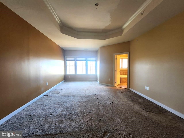 carpeted empty room with baseboards, a tray ceiling, and crown molding
