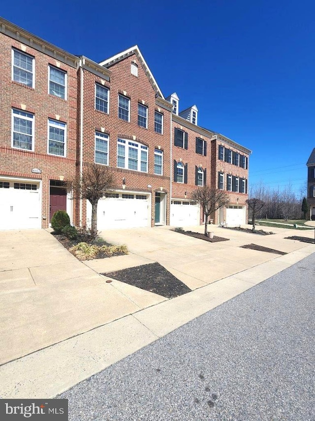 view of building exterior with driveway and an attached garage