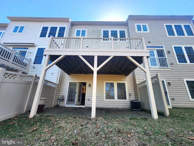 back of house featuring a lawn, a wooden deck, fence, and central AC
