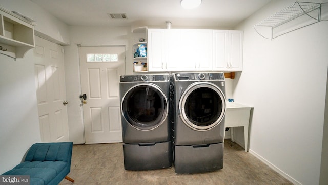 1601 Jubilation Ct, Herndon, VA 20170 - laundry area with washer and dryer, cabinet space, light tile patterned flooring, and baseboards