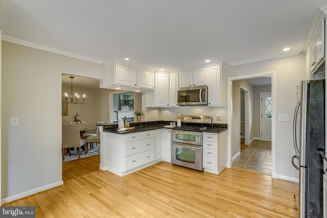 6515 Walters Woods Dr, Falls Church, VA 22044 - kitchen with white cabinets, stainless steel appliances, an inviting chandelier, light wood-style floors, and a peninsula