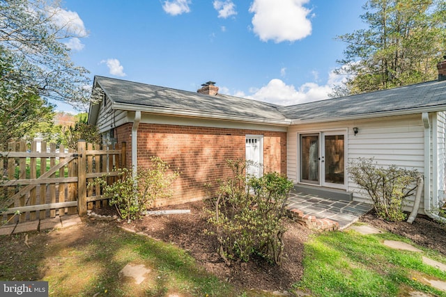 6515 Walters Woods Dr, Falls Church, VA 22044 - rear view of property featuring french doors, a chimney, fence, brick siding, and a patio