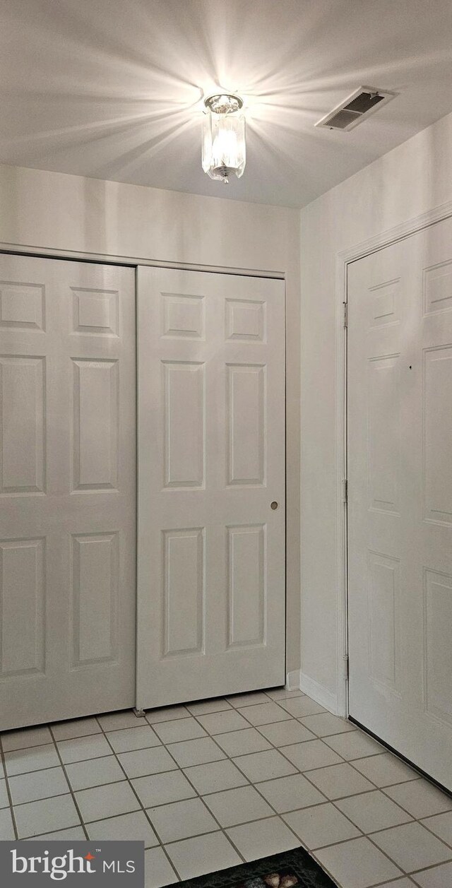entrance foyer with baseboards, light tile patterned flooring, and visible vents