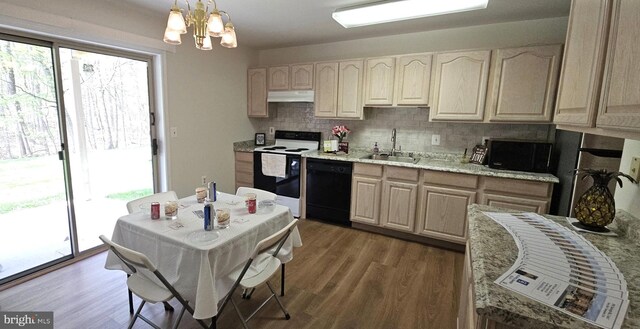 kitchen featuring a sink, a wealth of natural light, black appliances, and under cabinet range hood