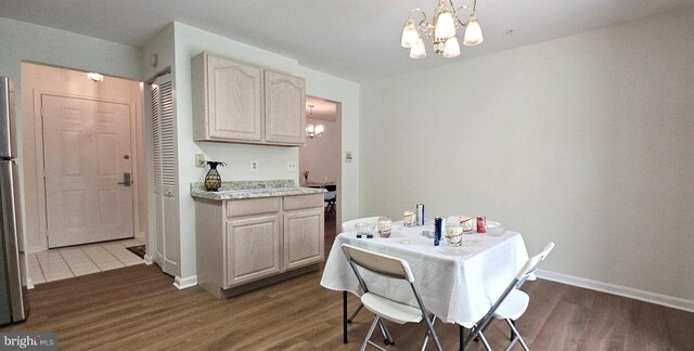 dining area with baseboards, dark wood-type flooring, and a chandelier