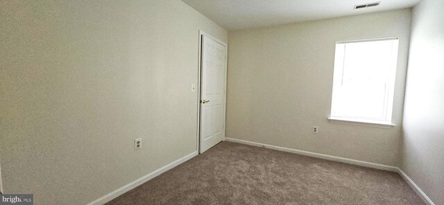 carpeted empty room with visible vents and baseboards