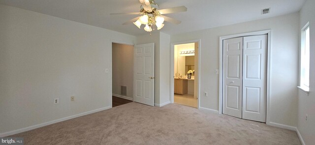unfurnished bedroom featuring carpet, baseboards, ensuite bathroom, visible vents, and a closet