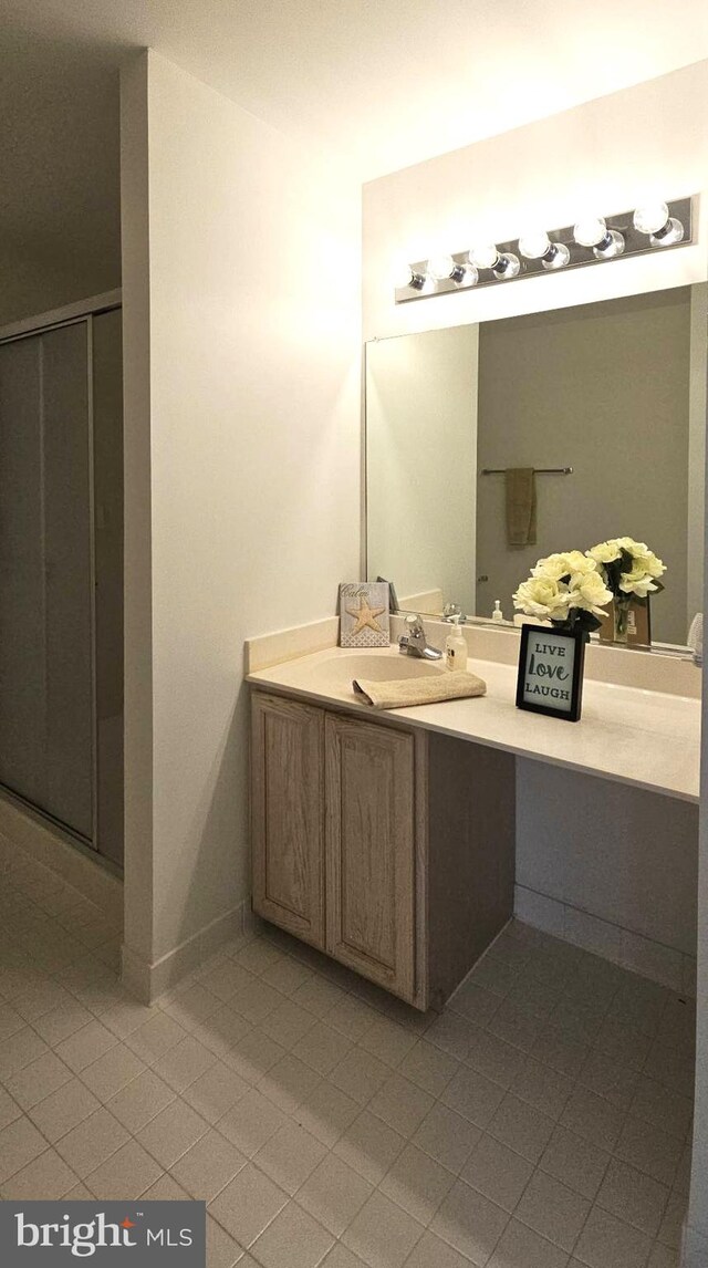 full bathroom with tile patterned floors, a shower stall, baseboards, and vanity