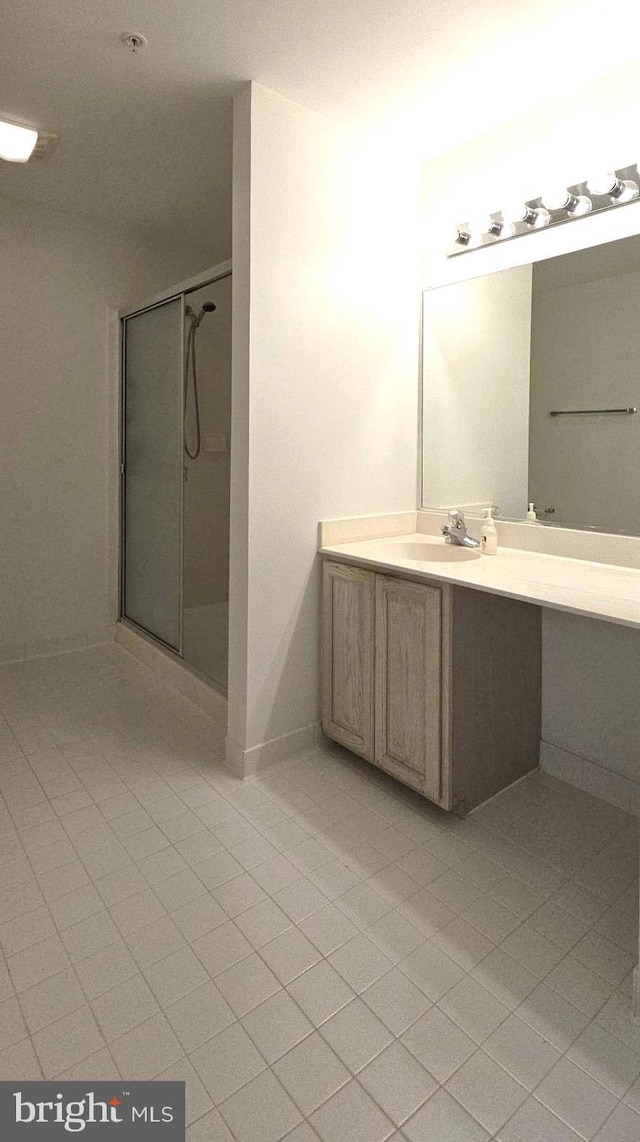 full bathroom with tile patterned floors, a shower stall, baseboards, and vanity
