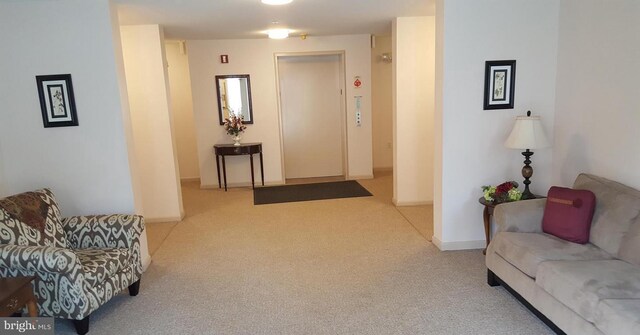 carpeted living room featuring baseboards