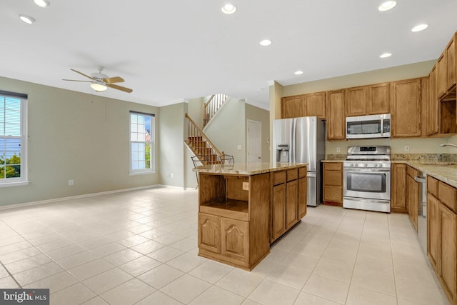 kitchen with light tile patterned floors, a wealth of natural light, and appliances with stainless steel finishes