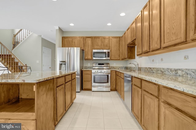 kitchen with light tile patterned floors, light stone countertops, a kitchen breakfast bar, a sink, and stainless steel appliances