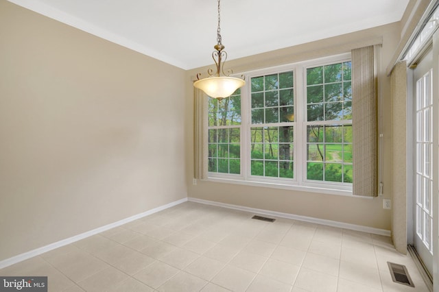 unfurnished dining area featuring baseboards, visible vents, and plenty of natural light