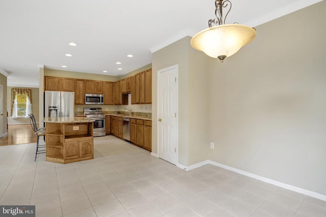 kitchen featuring a kitchen bar, a kitchen island, a sink, stainless steel appliances, and baseboards