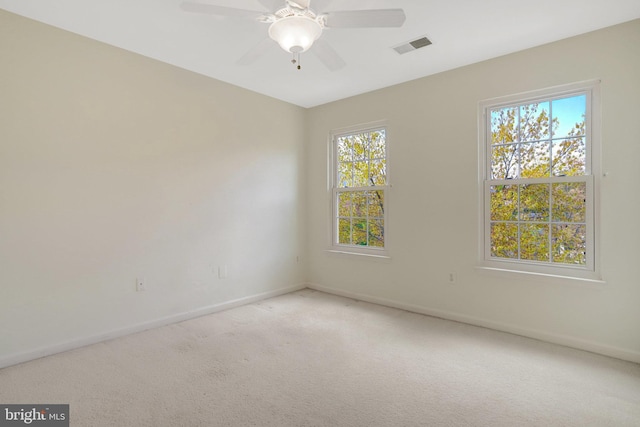 carpeted empty room featuring visible vents, baseboards, and ceiling fan