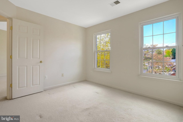 empty room featuring visible vents, baseboards, and carpet flooring