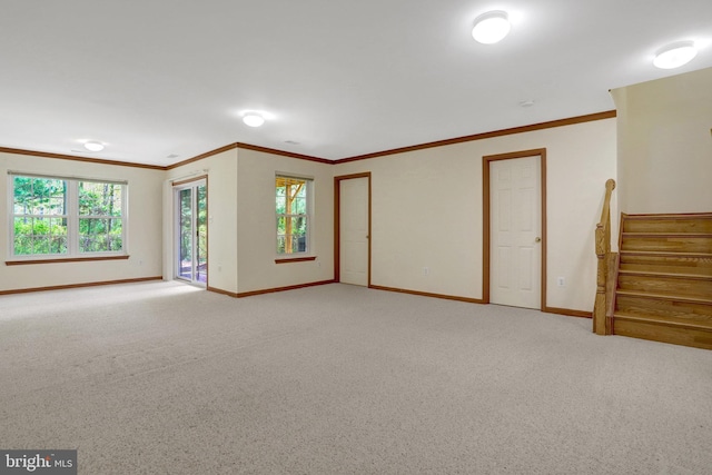 unfurnished living room with a wealth of natural light, crown molding, and baseboards