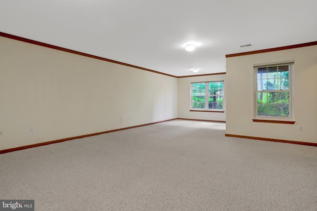 spare room featuring light carpet, visible vents, baseboards, and ornamental molding