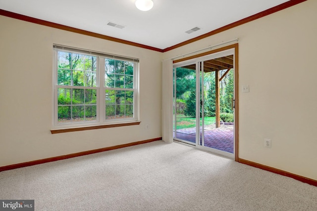 carpeted spare room featuring visible vents, baseboards, and ornamental molding