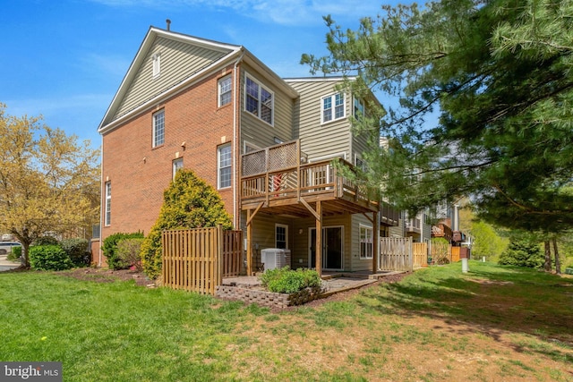 rear view of house featuring fence, central air condition unit, a lawn, brick siding, and a deck