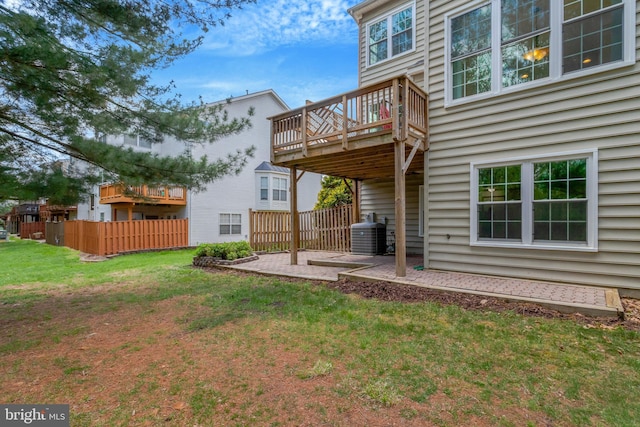 rear view of property featuring central AC, a patio area, a lawn, fence, and a wooden deck
