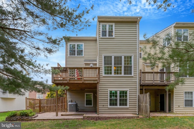 rear view of house featuring a wooden deck, a patio area, central AC unit, and fence