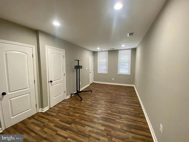 basement featuring dark wood-style flooring, recessed lighting, baseboards, and visible vents