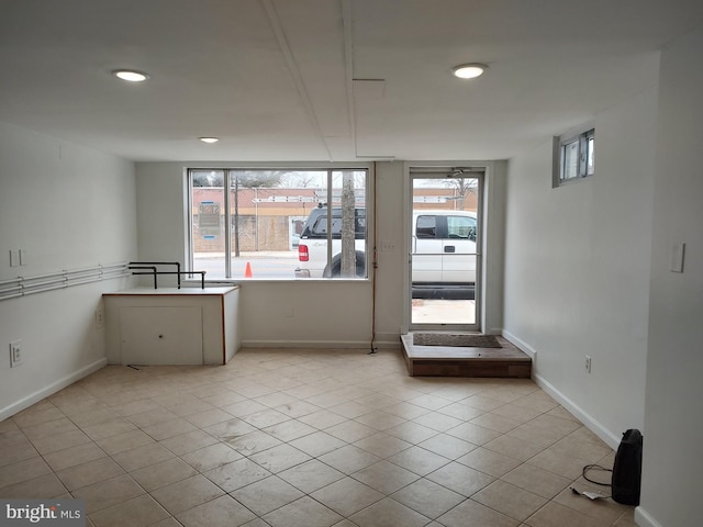empty room with light tile patterned flooring and baseboards