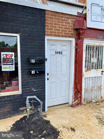doorway to property featuring brick siding