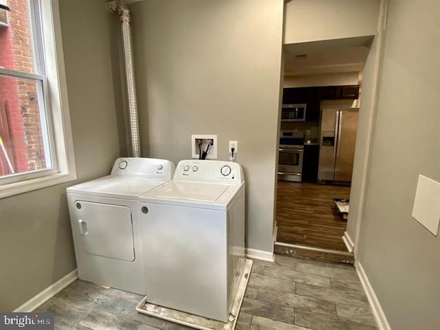 laundry area with baseboards, laundry area, and washer and clothes dryer