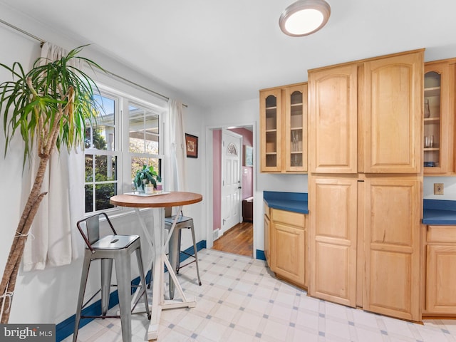 600 Maplewood Rd, Springfield, PA 19064 - kitchen with light brown cabinetry, dark countertops, glass insert cabinets, baseboards, and light floors