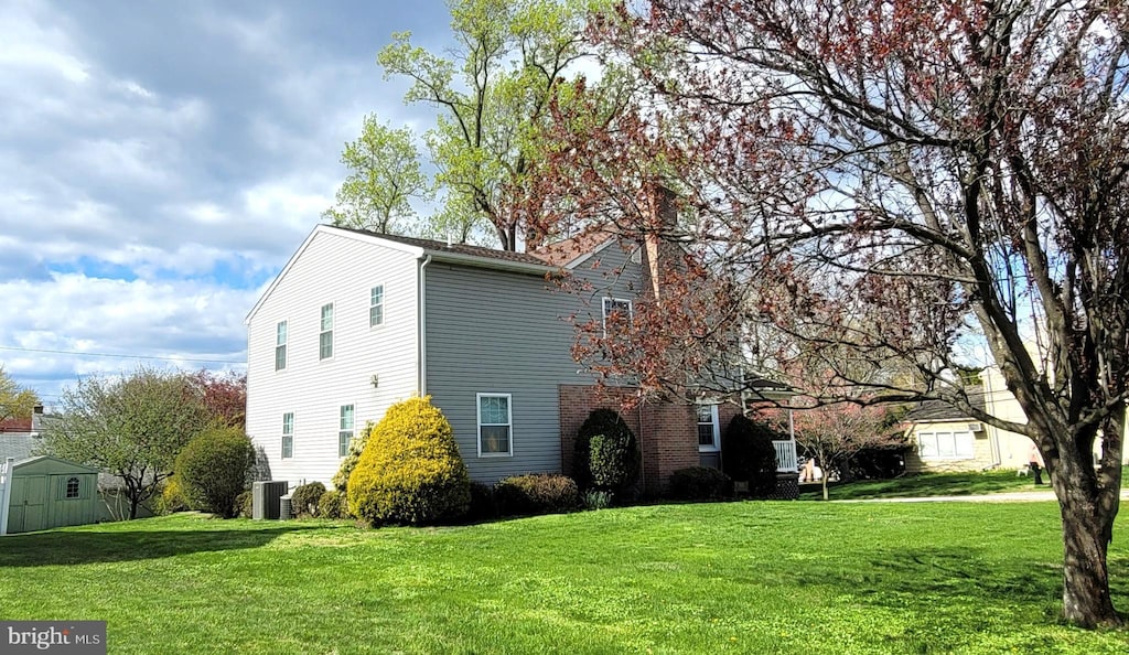 view of home's exterior featuring an outdoor structure, a shed, and a lawn